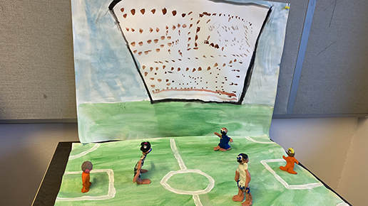eleverna har målat en fotbollsplan och skapat spelare med hjälp av lera