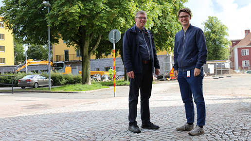 En politiker och en tjänsteman står på en gata som ska byggas ut.