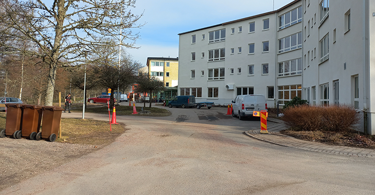Vitt hus med pågående ombyggnation, där byggmaterial syns runt om byggnaden."
