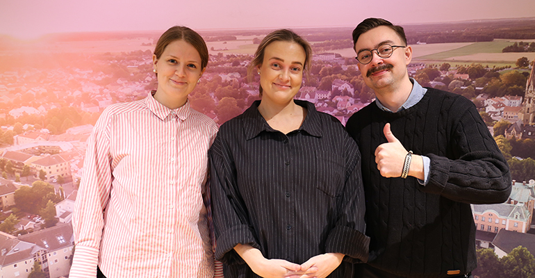 tre personer framför en vägg med digitaltryck