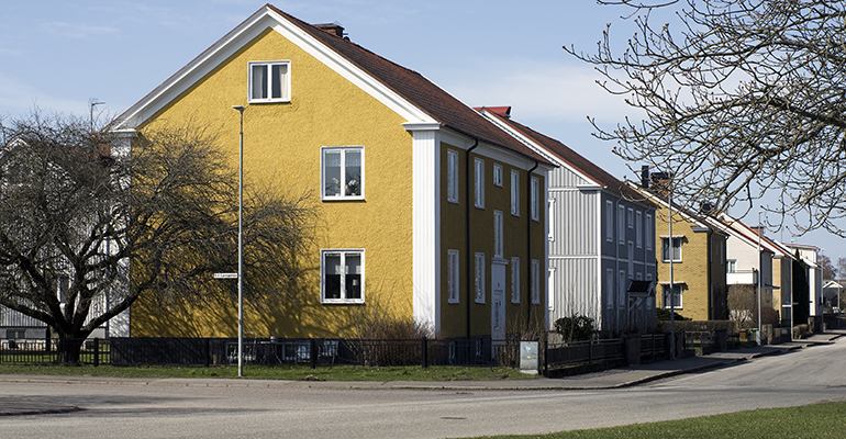 En gata med flerfamiljshus med rappade fasader.