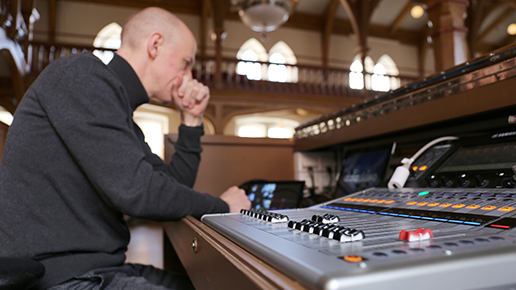 Tekniker Ola Johansson sitter koncentrerat vid sitt mixerbord i stadshuset.