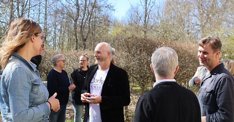 Flera personer står utomhus och minglar.