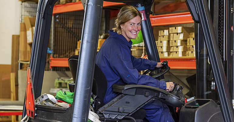 Lagerlokal, kvinna som arbetar med att köra truck