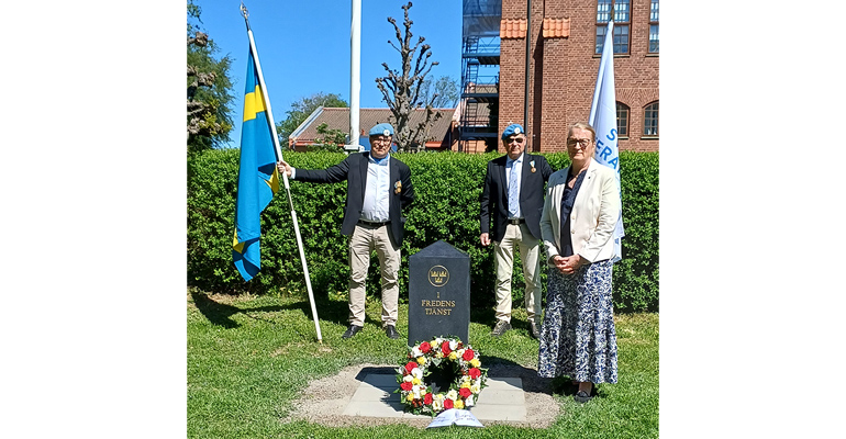 Tre personer vid ett monument