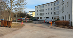 Vitt hus med pågående ombyggnation, där byggmaterial syns runt om byggnaden."